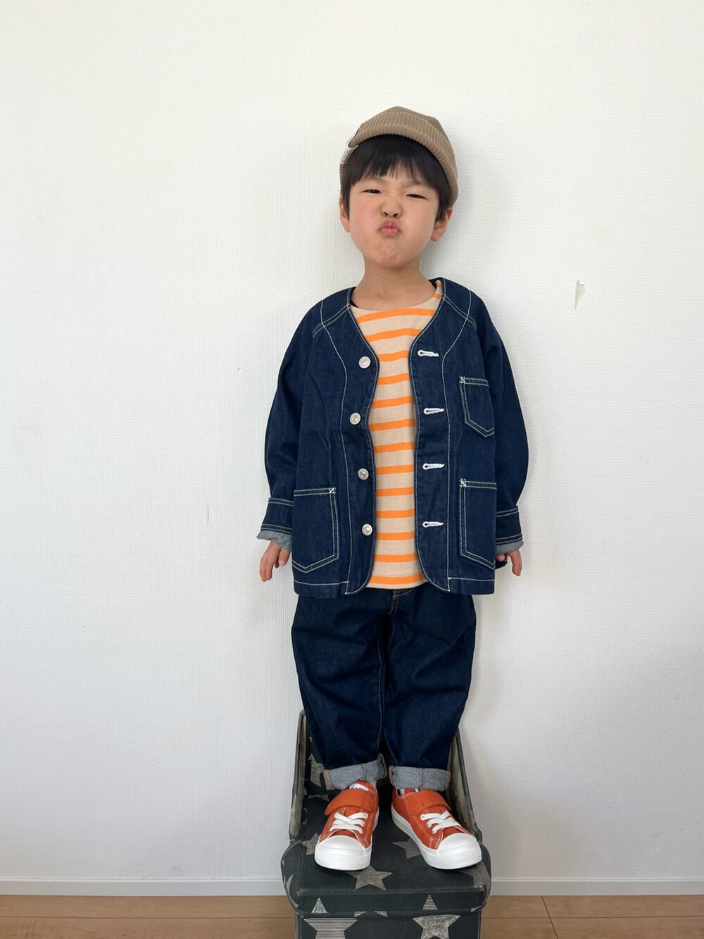 ブルー系のデニムジャケット、オレンジ系のTシャツ/カットソー、ブルー系のデニムパンツを着用したキッズの冬コーディネートの3枚目の写真