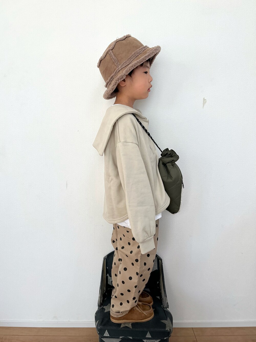 グリーン系のショルダーバッグ、ホワイト系のTシャツ/カットソー、ベージュ系のその他パンツを着用したキッズの冬コーディネートの3枚目の写真