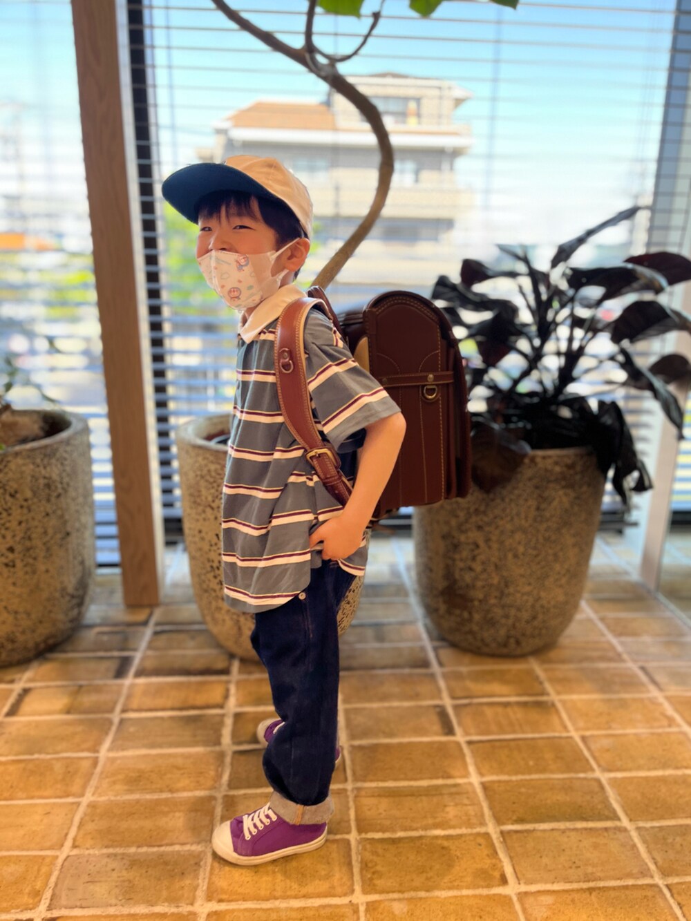 ブルー系のブルゾン、グリーン系のポロシャツ、ブルー系のデニムパンツを着用したキッズの春コーディネートの4枚目の写真