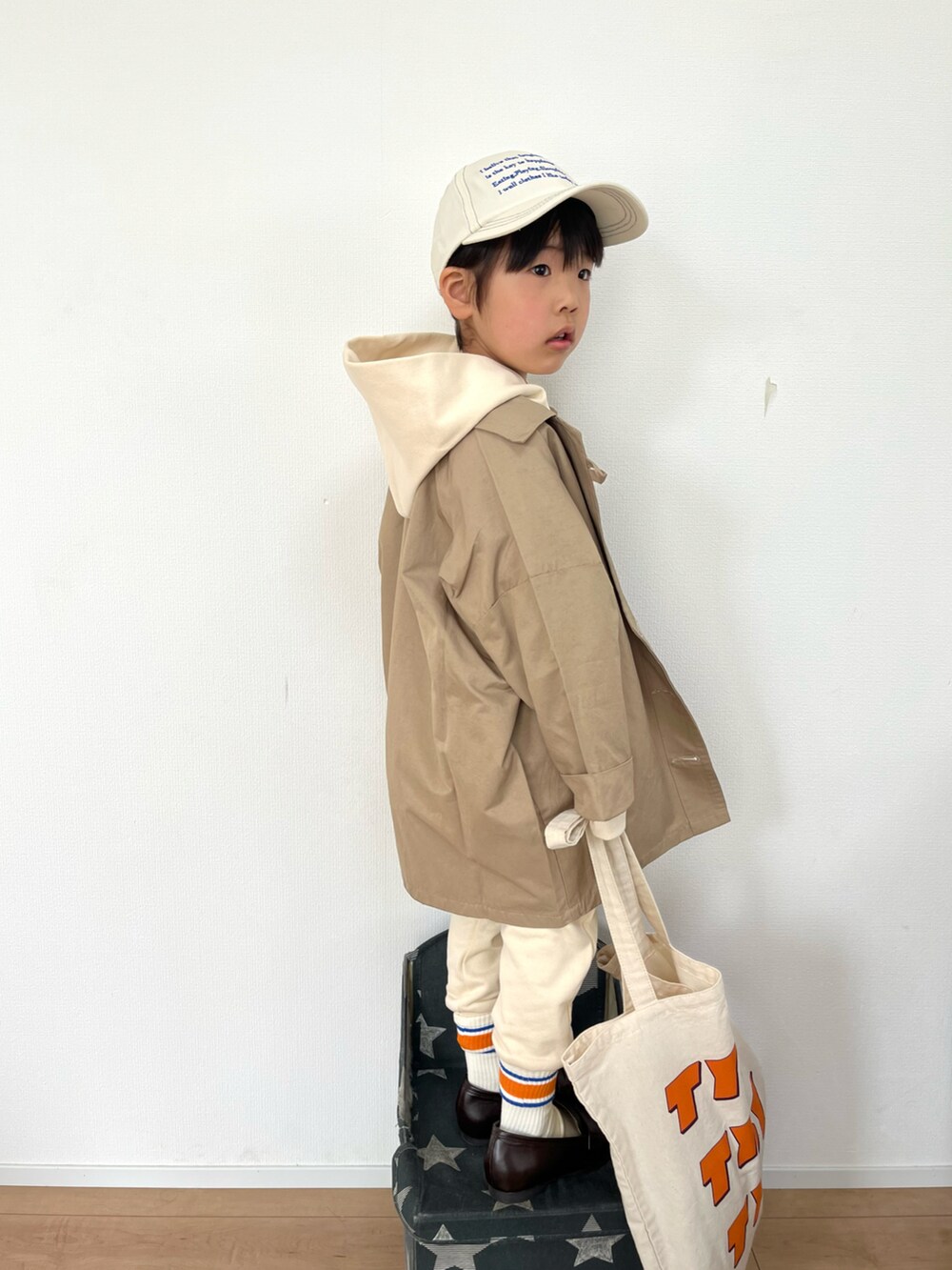 ベージュ系のトレンチコート、ホワイト系のTシャツ/カットソー、ホワイト系のその他パンツを着用したキッズの春コーディネートの2枚目の写真