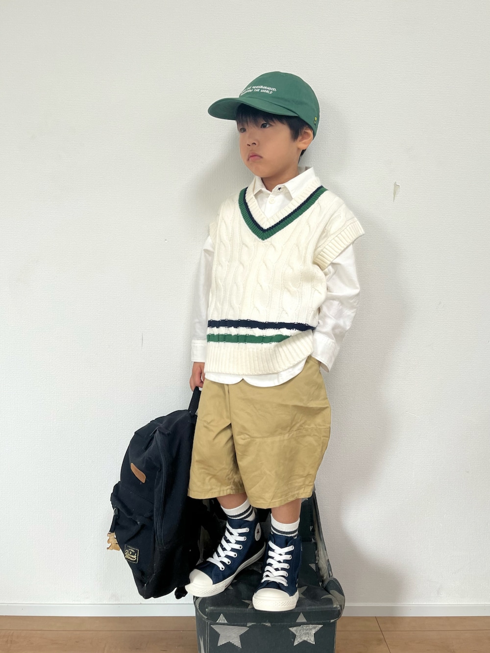 ホワイト系のベスト、ホワイト系のシャツ/ブラウス、ベージュ系のパンツを着用したキッズの秋コーディネートの2枚目の写真