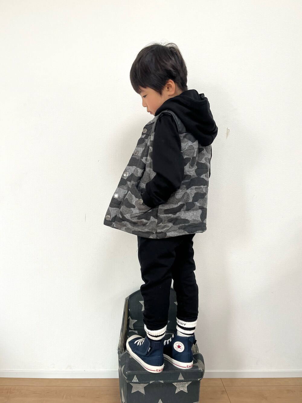 ブラック系のパーカー、ブラック系のスウェットパンツ、ブルー系のスニーカーを着用したキッズの秋コーディネートの3枚目の写真