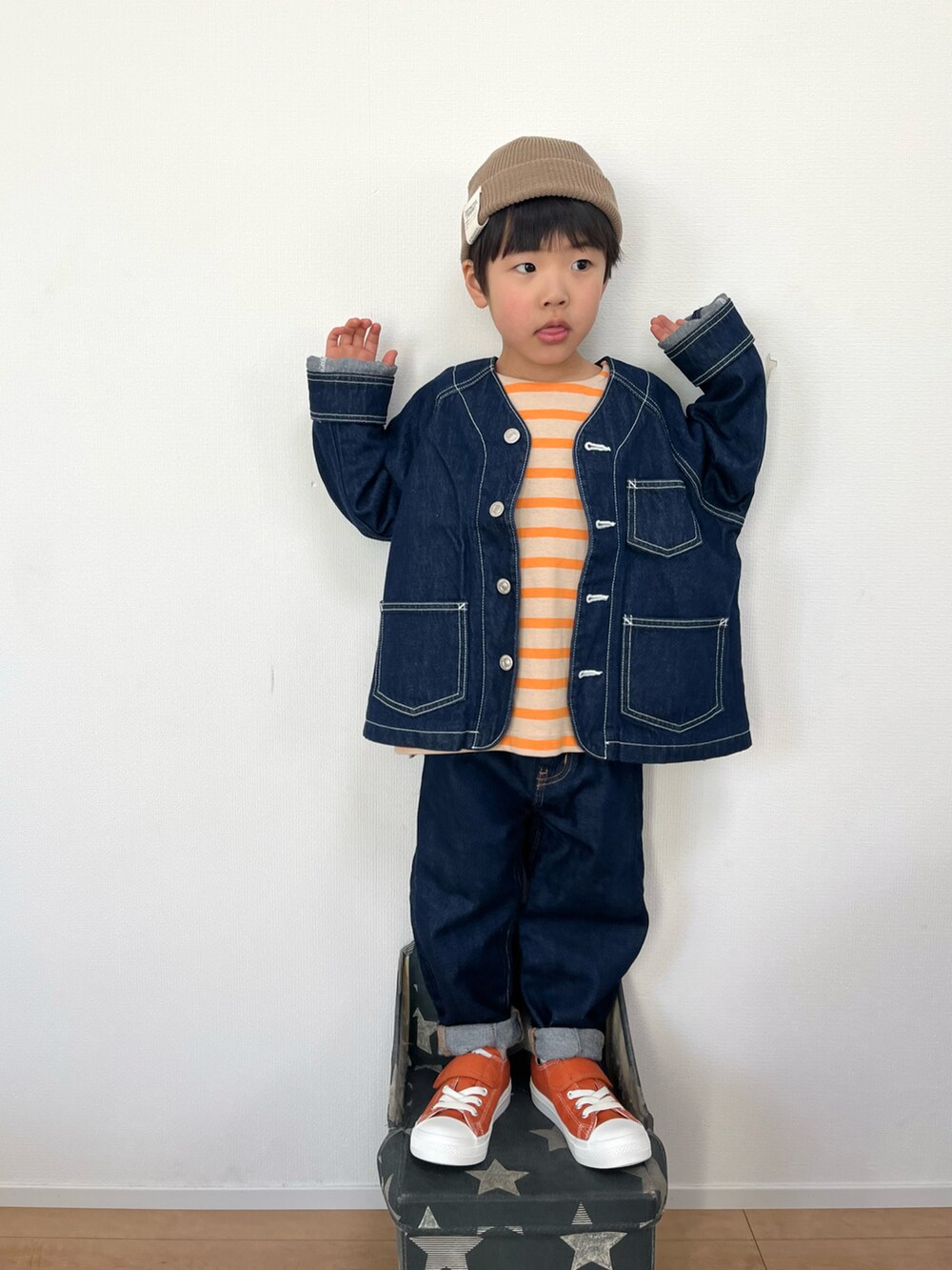 ブルー系のデニムジャケット、オレンジ系のTシャツ/カットソー、ブルー系のデニムパンツを着用したキッズの冬コーディネートの2枚目の写真