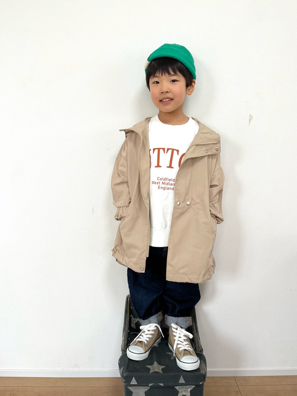 ベージュ系のブルゾン、ホワイト系のスウェット、ブルー系のデニムパンツを着用したキッズの冬コーディネートの2枚目の写真