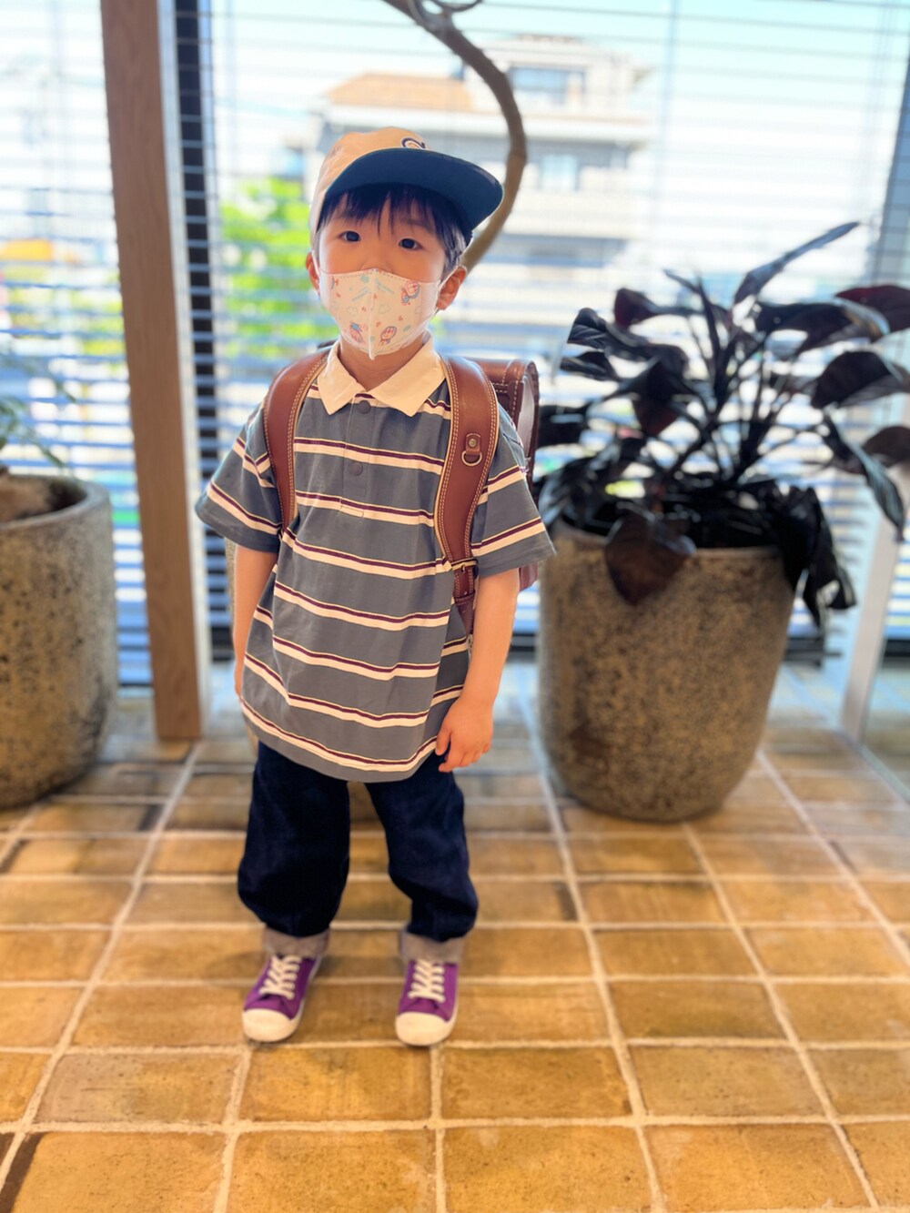 ブルー系のブルゾン、グリーン系のポロシャツ、ブルー系のデニムパンツを着用したキッズの春コーディネートの3枚目の写真