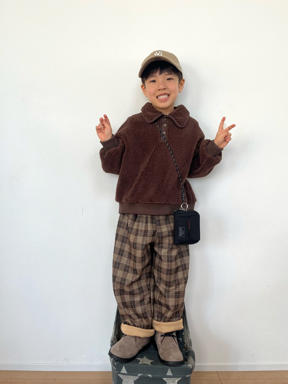 ブラウン系のTシャツ/カットソー、ブラウン系のパンツ、ブラウン系のその他シューズを着用したキッズの冬コーディネートの3枚目の写真