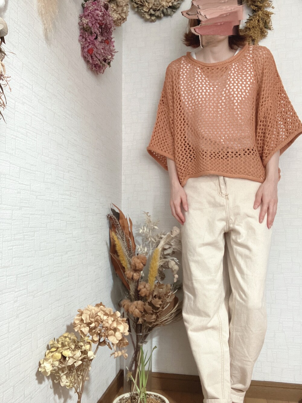 ベージュ系のデニムパンツ、ホワイト系のTシャツ/カットソー、オレンジ系のニット/セーターを着用したレディースの夏コーディネートの2枚目の写真