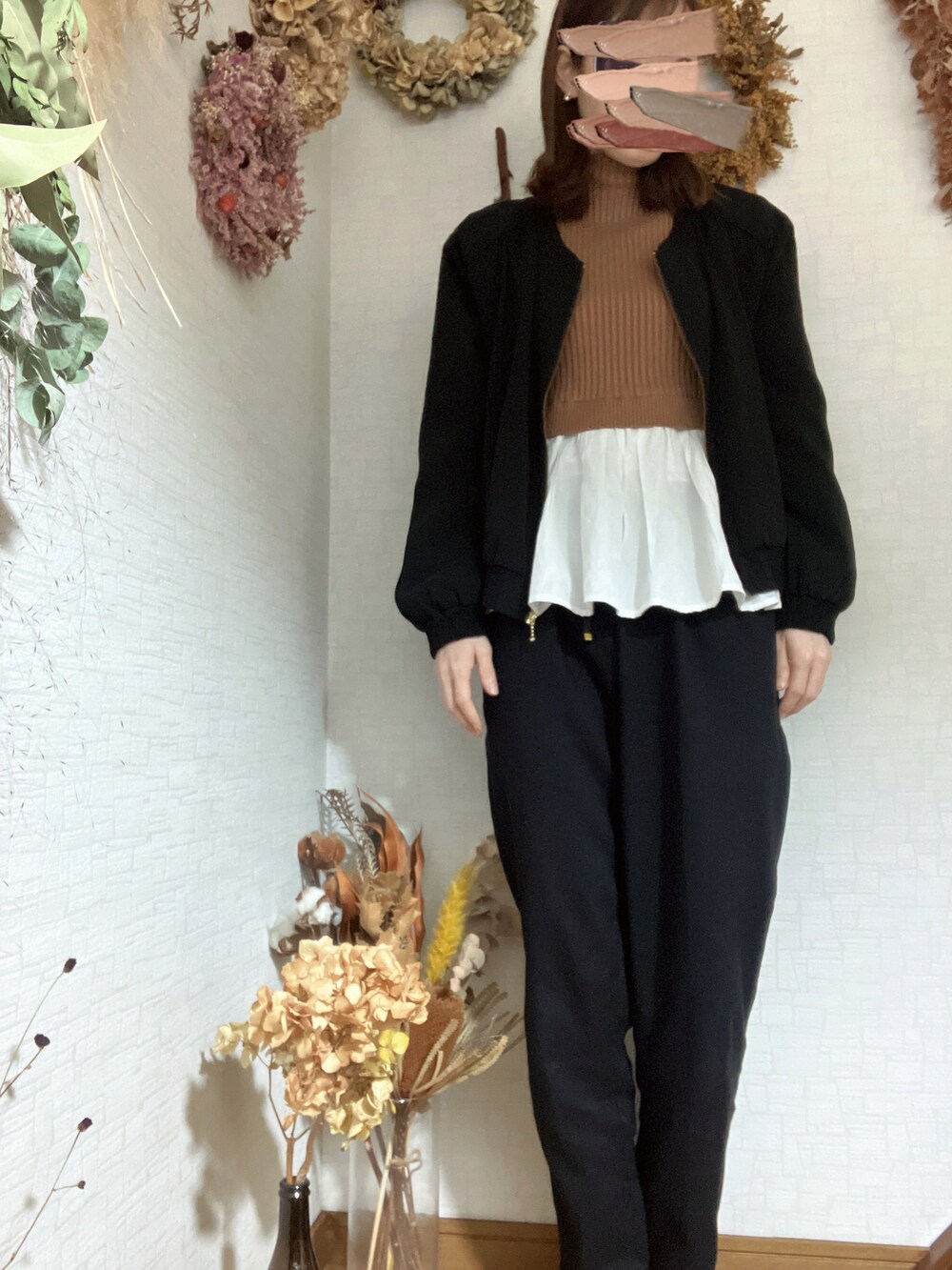 ブラック系のスラックス、ブラウン系のニット/セーター、ゴールド系のピアス（両耳用）を着用したレディースの秋コーディネートの2枚目の写真