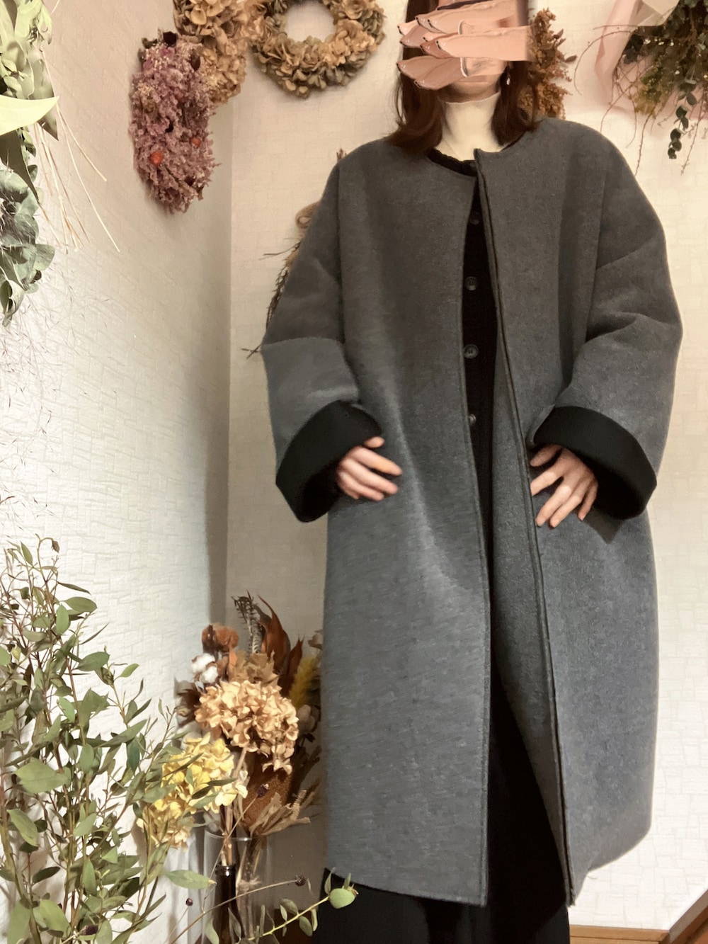 ホワイト系のニット/セーター、ブラック系のスカート、ブラック系のカーディガン/ボレロを着用したレディースの冬コーディネートの2枚目の写真