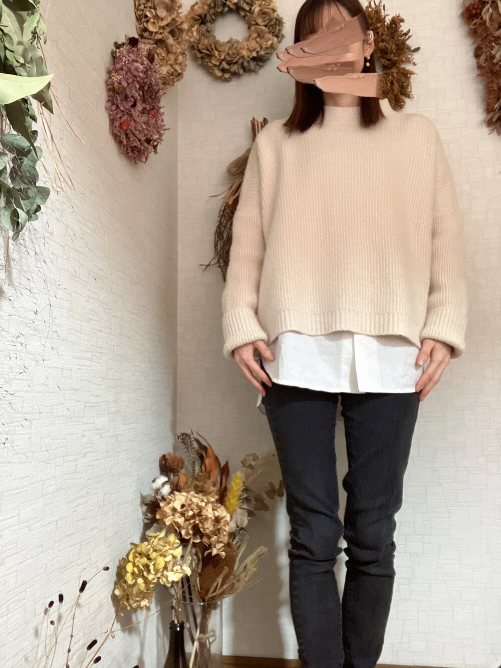 ブラック系のデニムパンツ、ホワイト系のニット/セーター、ホワイト系のジャケット/アウターを着用したレディースの冬コーディネートの2枚目の写真