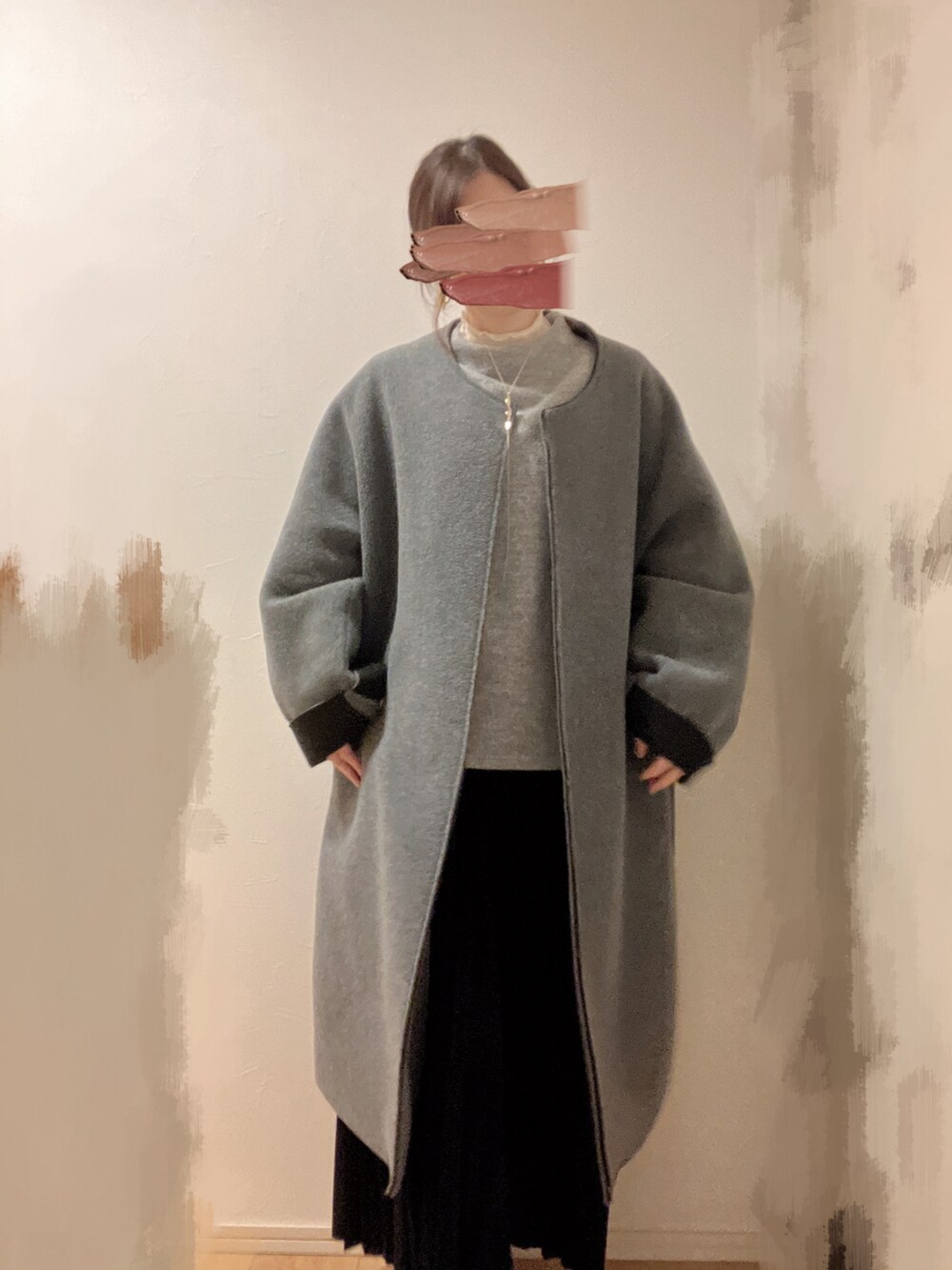 ブラック系のスカート、グレー系のニット/セーター、ベージュ系のTシャツ/カットソーを着用したレディースの冬コーディネートの2枚目の写真