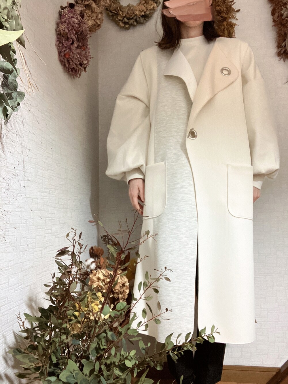 ホワイト系のベストを着用したレディースの冬コーディネートの2枚目の写真