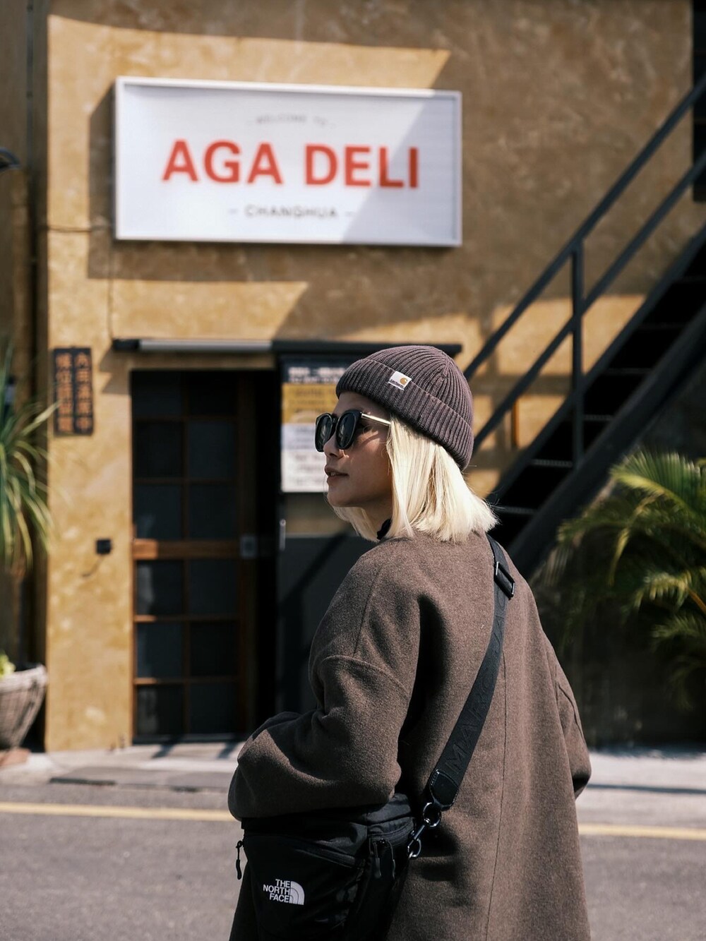 ブルー系のパンツ、グレー系のシューズ、ブラック系の帽子を着用したレディースの春コーディネートの2枚目の写真