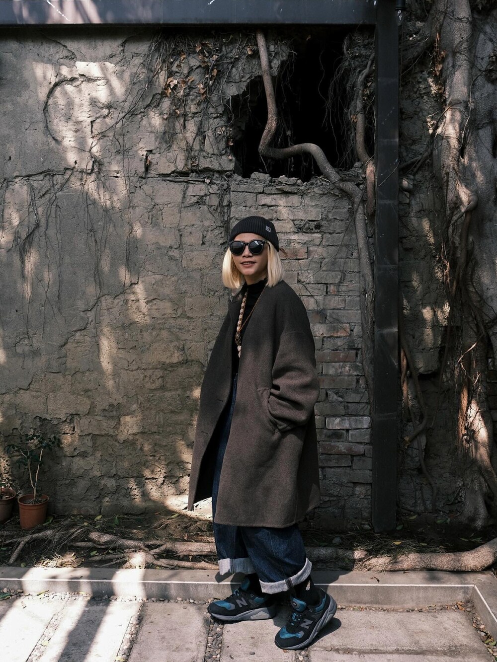 ブルー系のパンツ、グレー系のシューズ、ブラック系の帽子を着用したレディースの春コーディネートの4枚目の写真