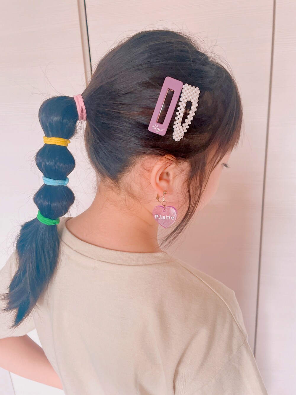 ベージュ系のTシャツ/カットソー、パープル系のスカート、ベージュ系のスニーカーを着用したキッズの夏コーディネートの3枚目の写真