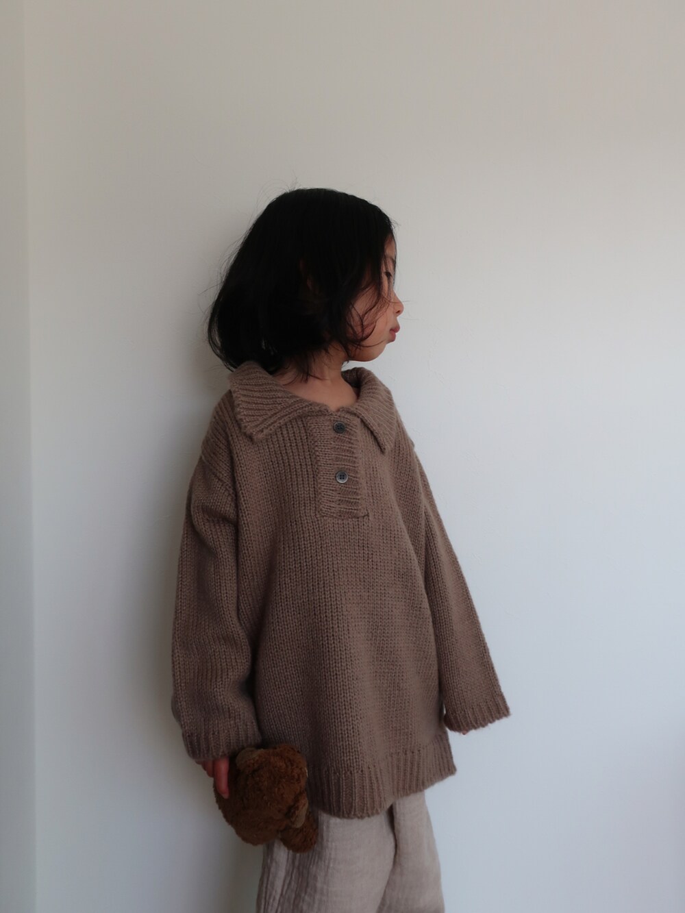 ブラウン系のニット/セーターを着用したキッズの冬コーディネートの3枚目の写真