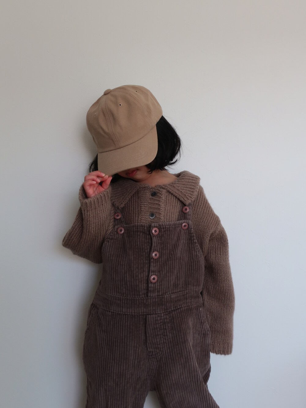 ブラウン系のニット/セーターを着用したキッズの冬コーディネートの2枚目の写真