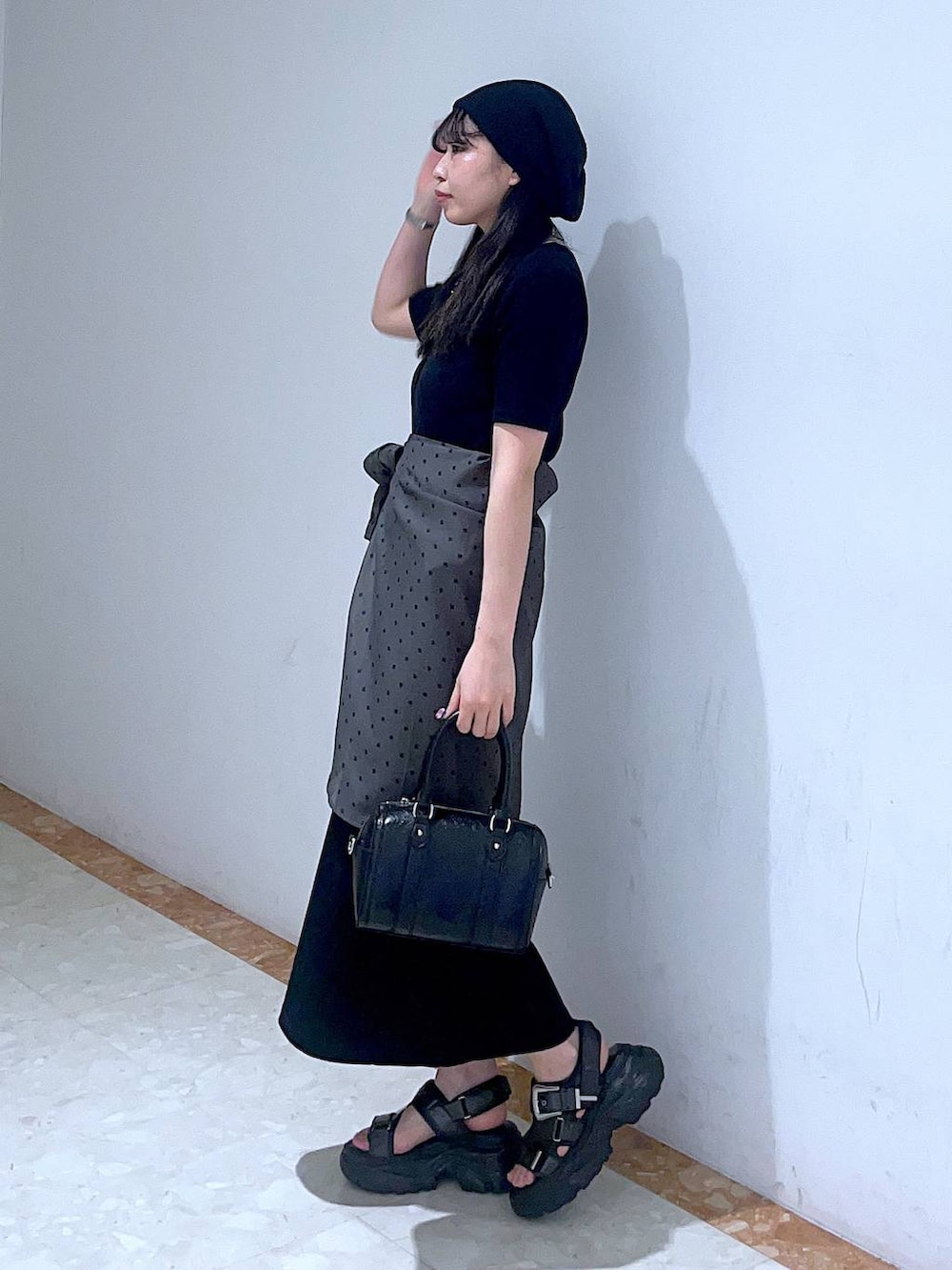 ブラック系のボストンバッグ、ブルー系のタンクトップ、ブラック系のサンダルを着用したレディースの春コーディネートの2枚目の写真