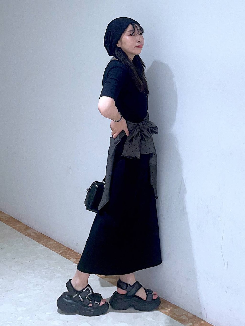 ブラック系のボストンバッグ、ブルー系のタンクトップ、ブラック系のサンダルを着用したレディースの春コーディネートの4枚目の写真