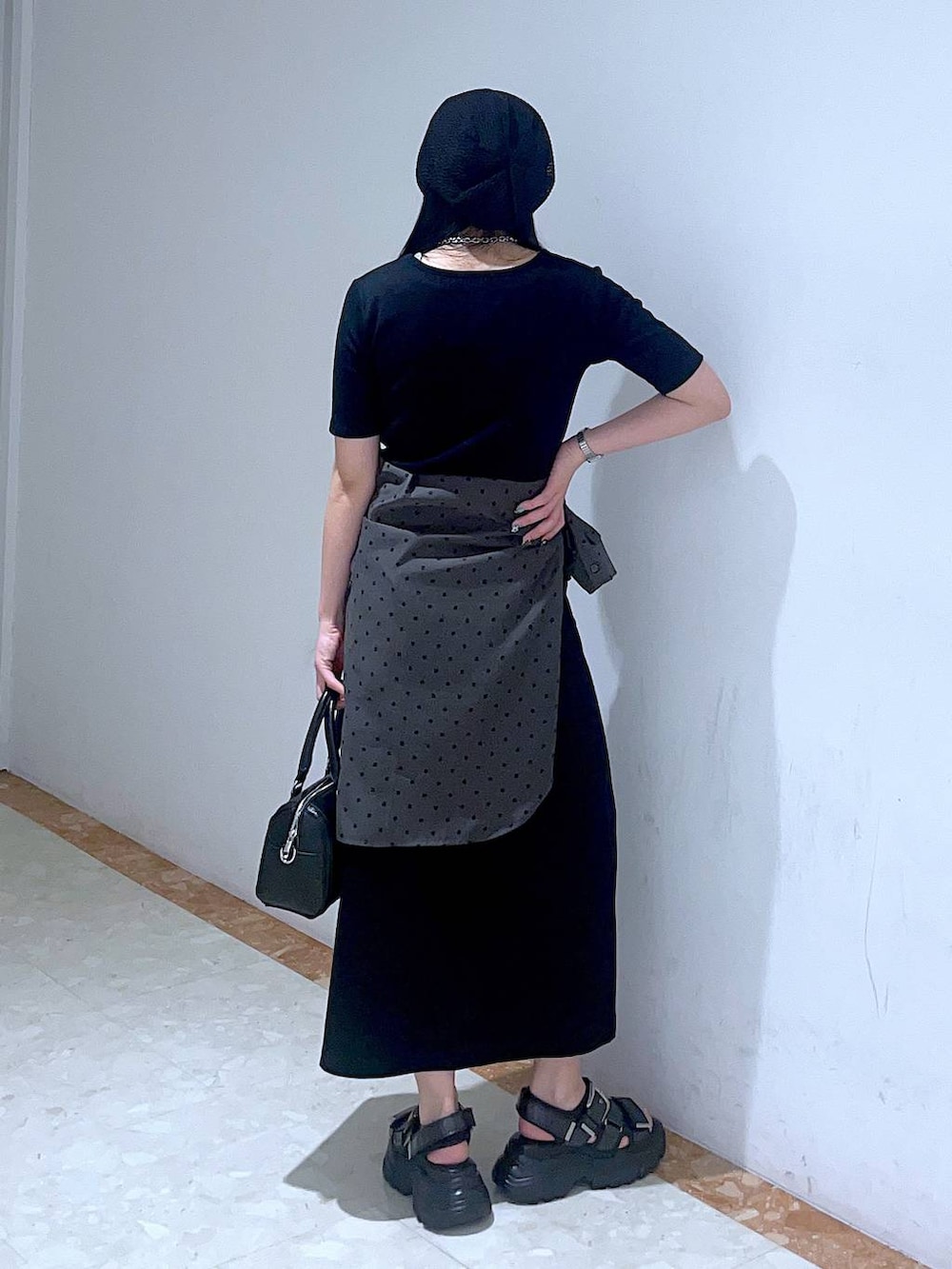 ブラック系のボストンバッグ、ブルー系のタンクトップ、ブラック系のサンダルを着用したレディースの春コーディネートの3枚目の写真