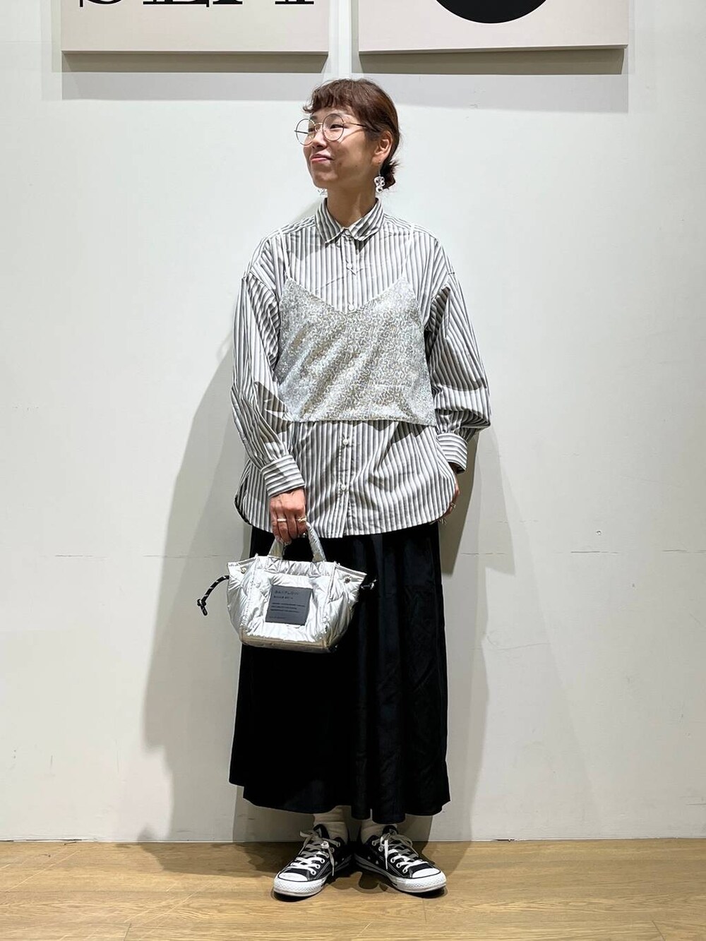 シルバー系のショルダーバッグ、シルバー系のベスト、ブラック系のその他パンツを着用したレディースの夏コーディネートの5枚目の写真