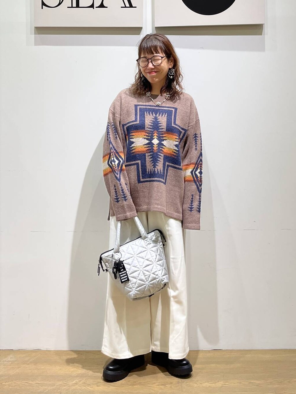 ベージュ系のその他パンツ、ブラック系のブーツ、シルバー系のトートバッグを着用したレディースの秋コーディネートの5枚目の写真