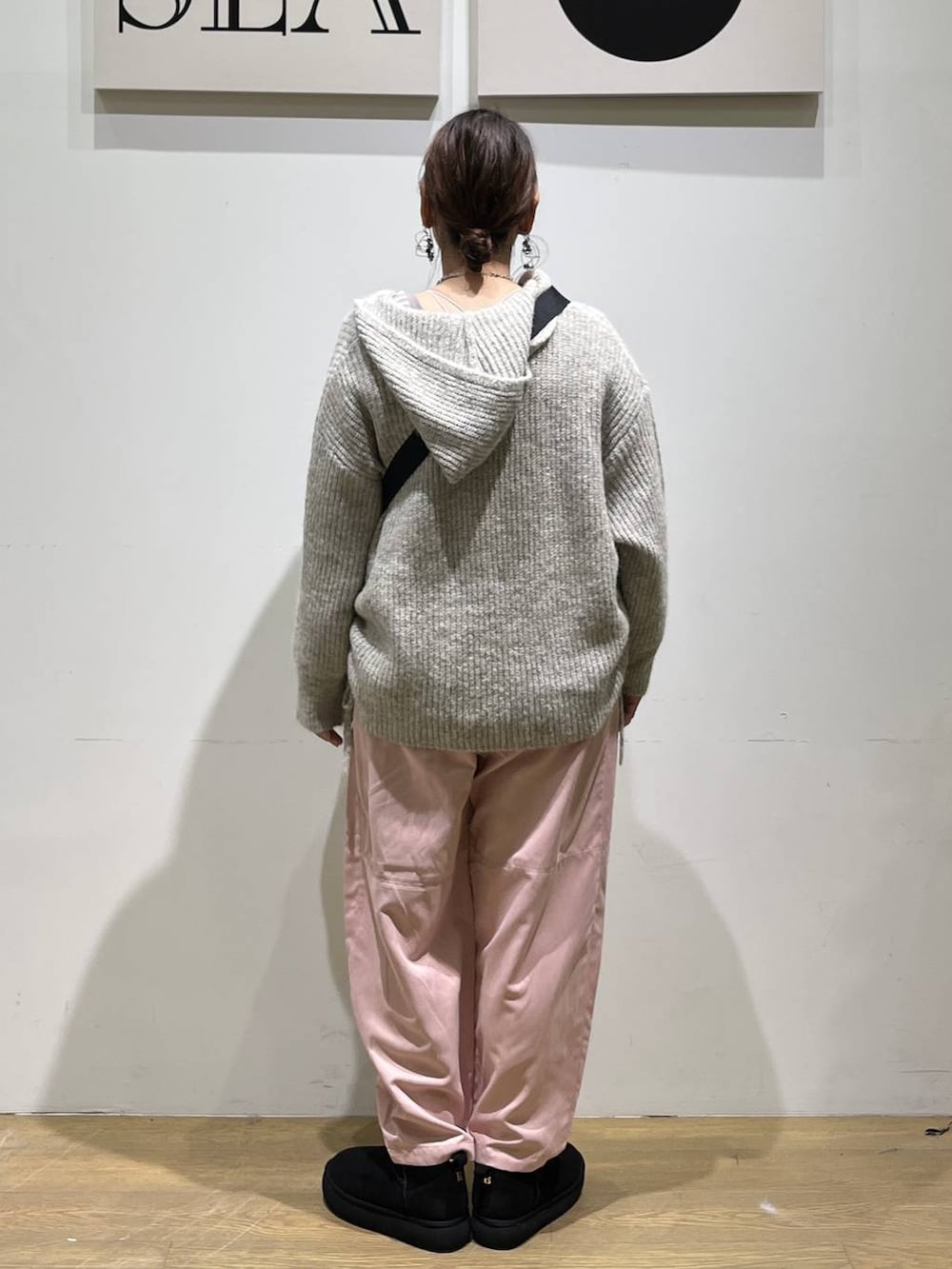 ブラック系のトートバッグ、ベージュ系のTシャツ/カットソー、ブラック系のブーツを着用したレディースの秋コーディネートの3枚目の写真