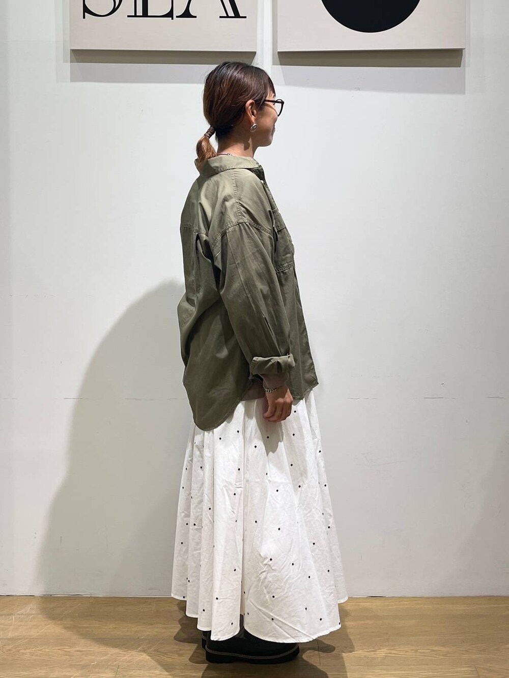 グリーン系のシャツ/ブラウス、ブラウン系のTシャツ/カットソー、ホワイト系のスカートを着用したレディースの秋コーディネートの4枚目の写真