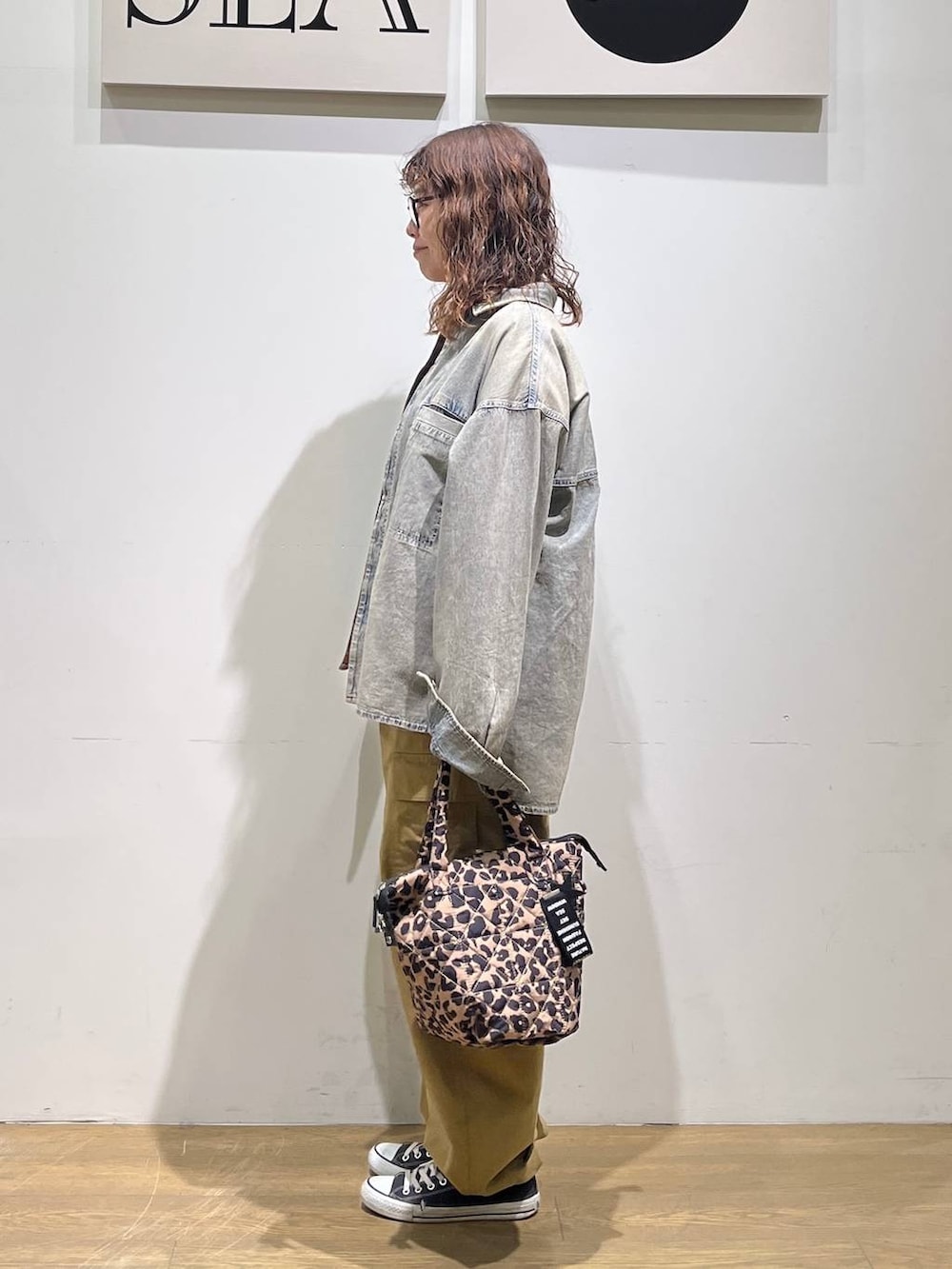 レッド系のTシャツ/カットソー、ベージュ系のカーゴパンツ、ブルー系のシャツ/ブラウスを着用したレディースの冬コーディネートの2枚目の写真