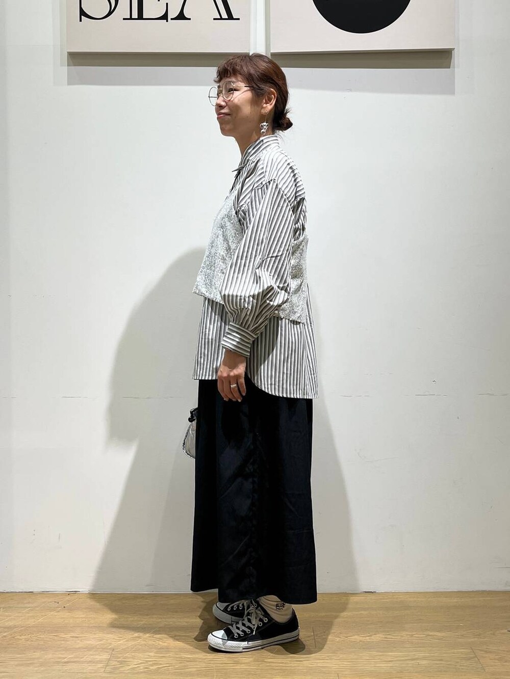 シルバー系のショルダーバッグ、シルバー系のベスト、ブラック系のその他パンツを着用したレディースの夏コーディネートの2枚目の写真