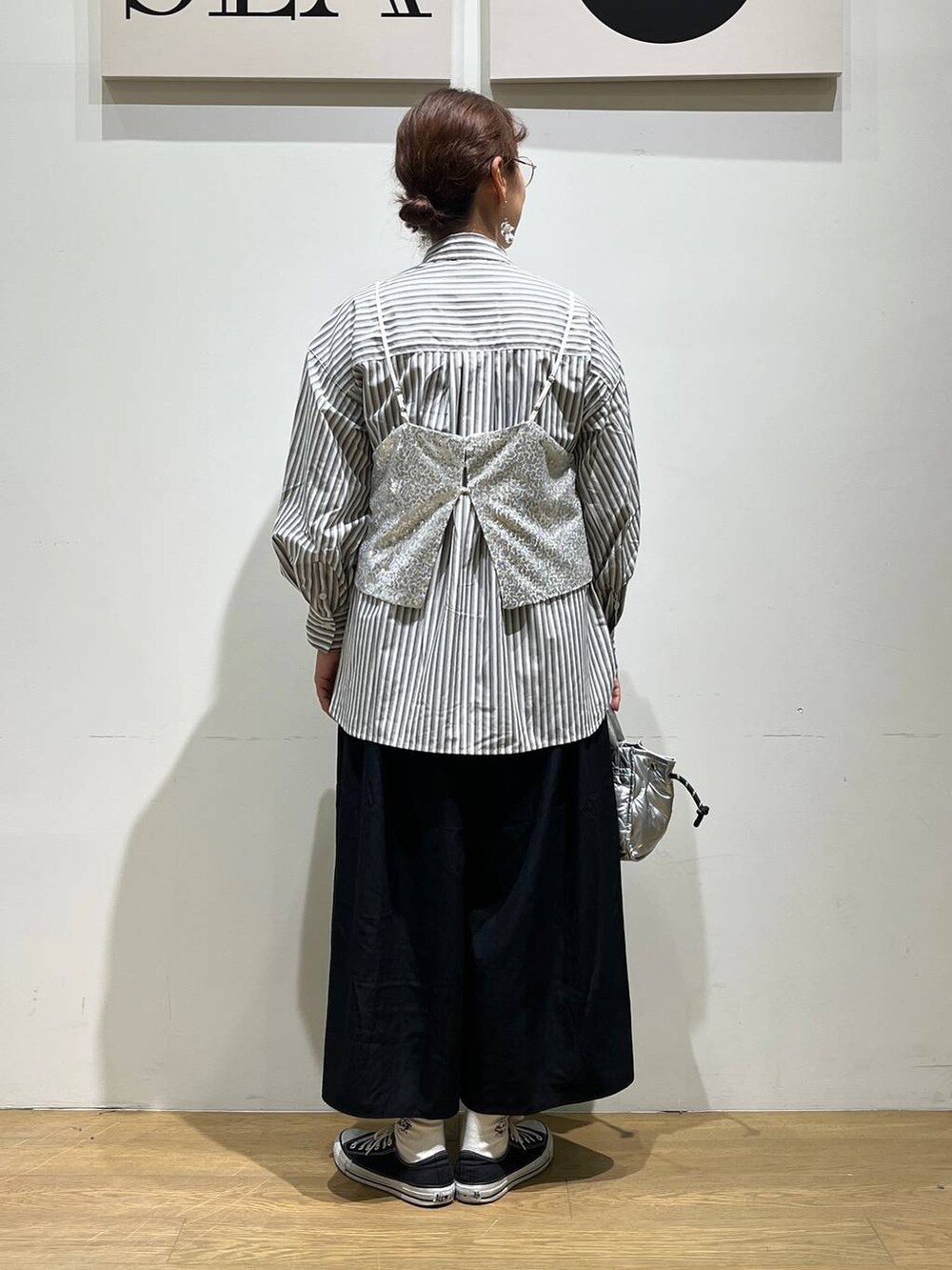 シルバー系のショルダーバッグ、シルバー系のベスト、ブラック系のその他パンツを着用したレディースの夏コーディネートの3枚目の写真