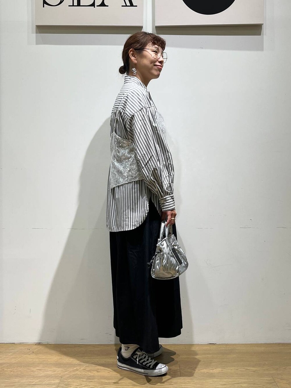 シルバー系のショルダーバッグ、シルバー系のベスト、ブラック系のその他パンツを着用したレディースの夏コーディネートの4枚目の写真