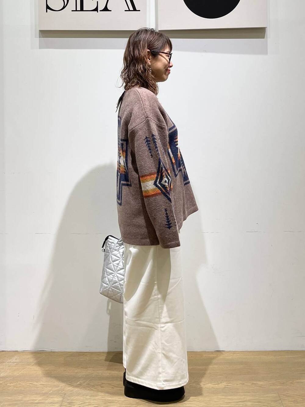 ベージュ系のその他パンツ、ブラック系のブーツ、シルバー系のトートバッグを着用したレディースの秋コーディネートの4枚目の写真