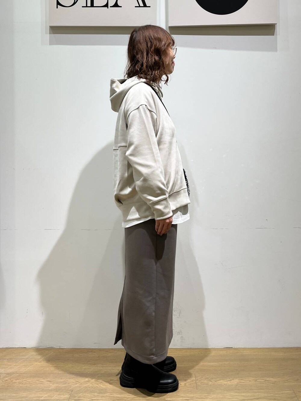 グレー系のショルダーバッグ、ホワイト系のTシャツ/カットソー、ブラック系のブーツを着用したレディースの冬コーディネートの4枚目の写真