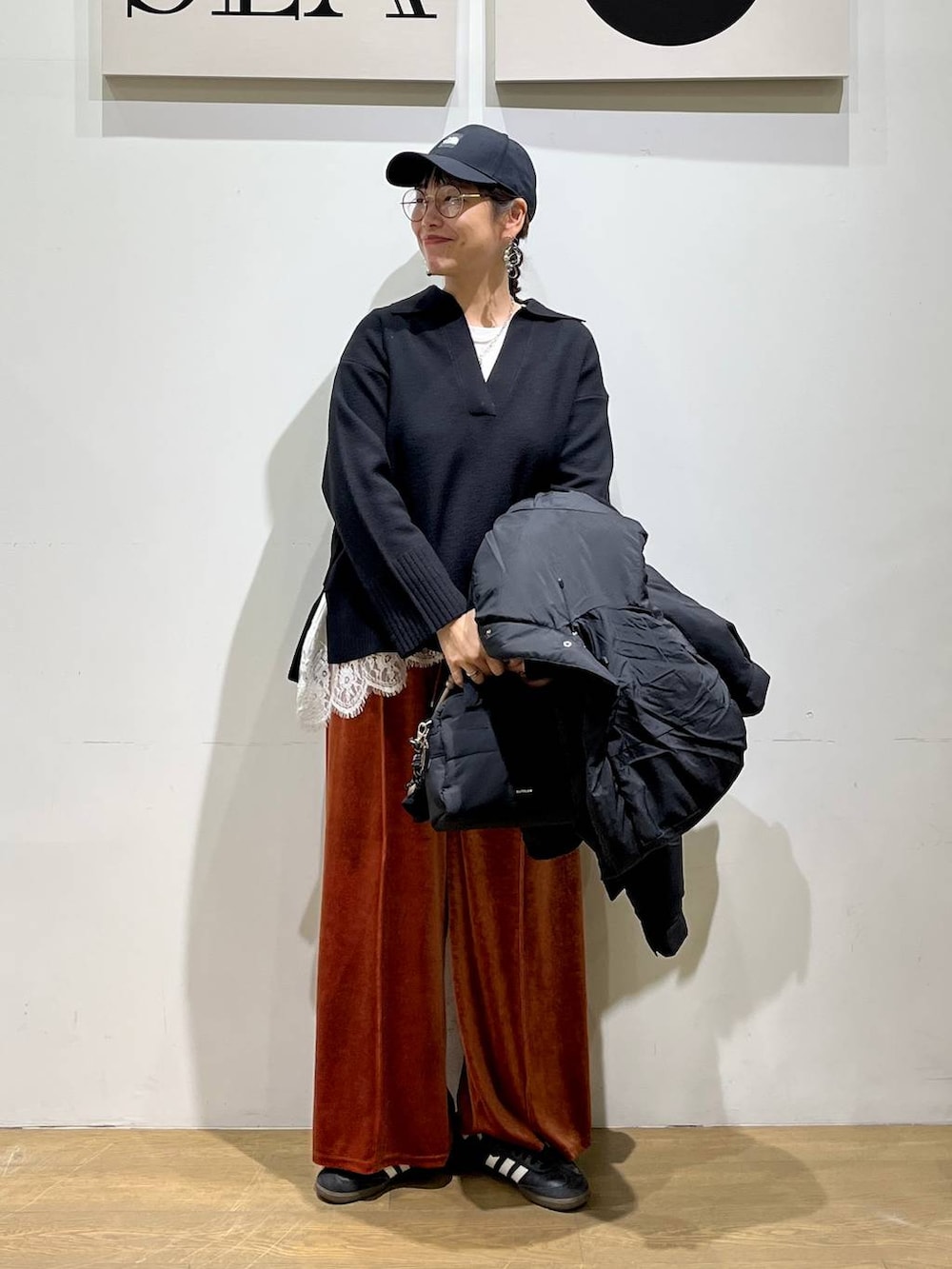 ブラック系のダウンジャケット/コート、レッド系のその他パンツ、ブラック系のボストンバッグを着用したレディースの冬コーディネートの2枚目の写真