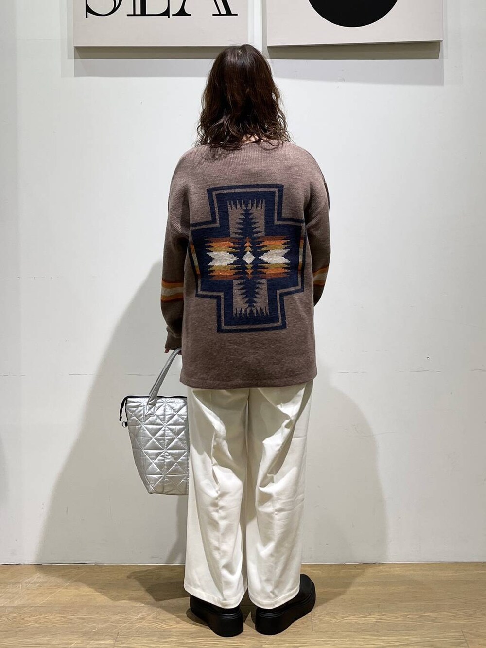 ベージュ系のその他パンツ、ブラック系のブーツ、シルバー系のトートバッグを着用したレディースの秋コーディネートの3枚目の写真