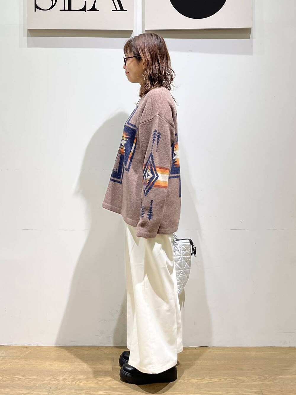 ベージュ系のその他パンツ、ブラック系のブーツ、シルバー系のトートバッグを着用したレディースの秋コーディネートの2枚目の写真