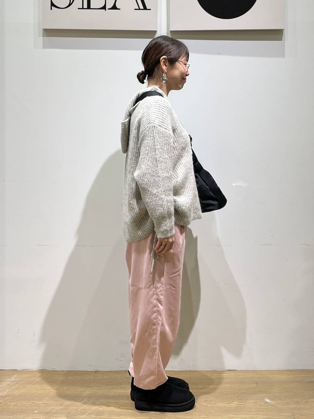 ブラック系のトートバッグ、ベージュ系のTシャツ/カットソー、ブラック系のブーツを着用したレディースの秋コーディネートの4枚目の写真