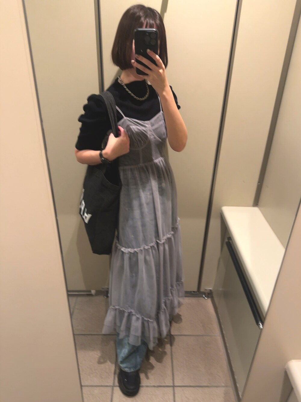 ブルー系のトートバッグ、ブラック系のニット/セーター、ブルー系のデニムパンツを着用したレディースの秋コーディネートの2枚目の写真