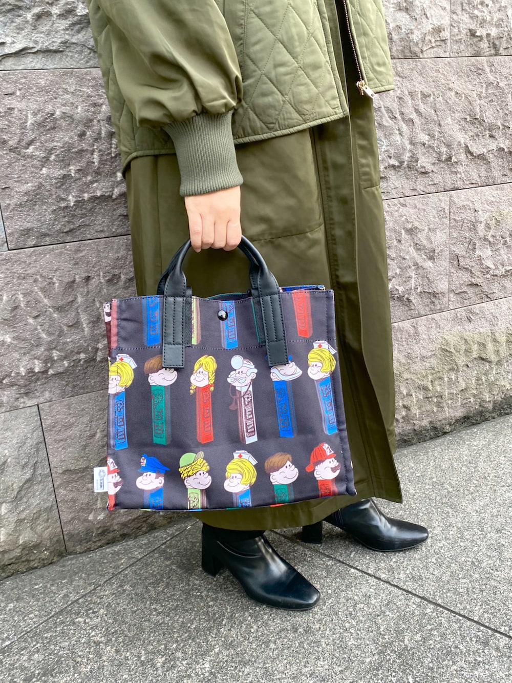 ブラック系のトートバッグ、グリーン系のノーカラーコート、ブラック系のブーツを着用したレディースの秋コーディネートの2枚目の写真