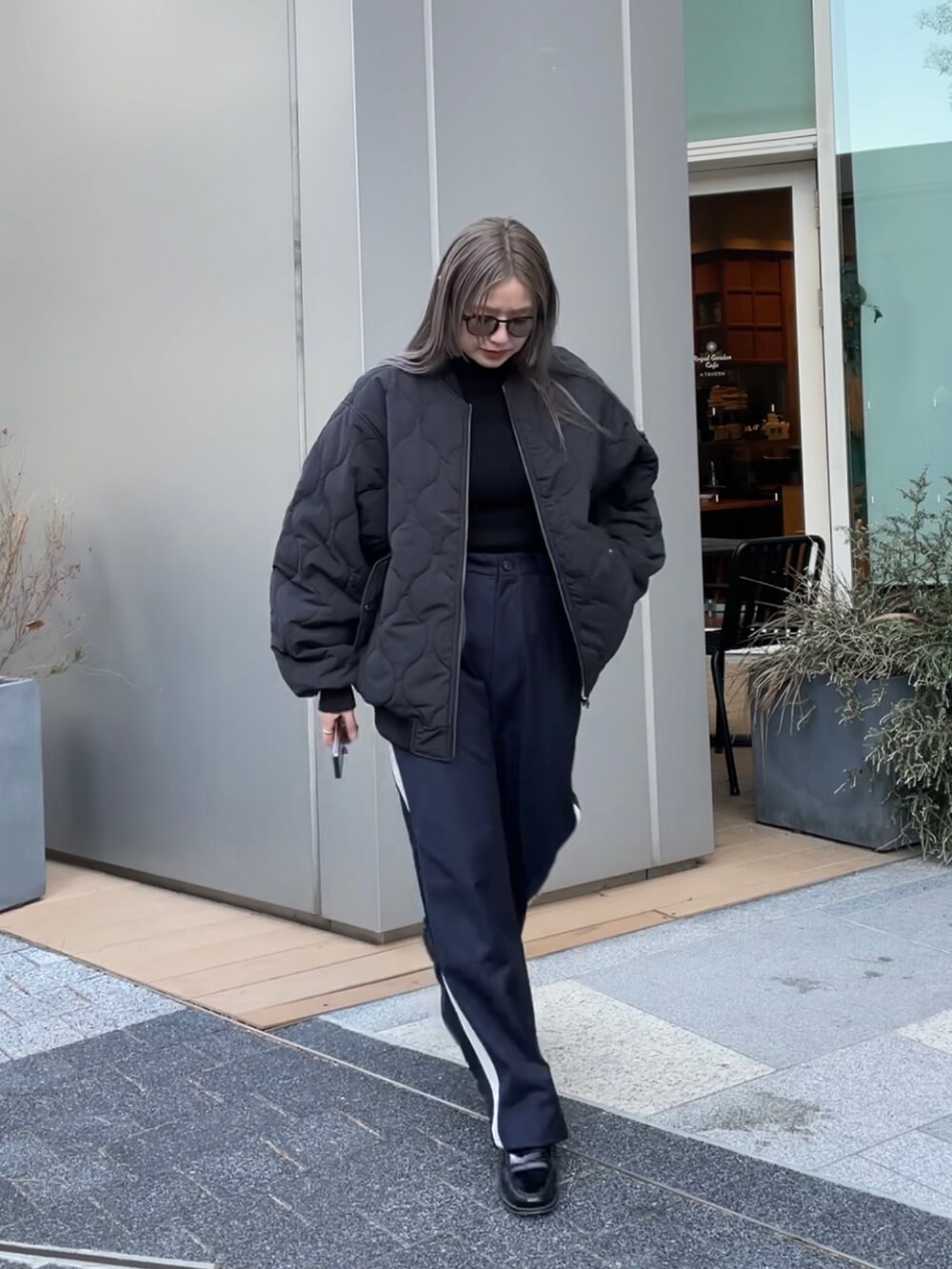 ブラック系のジャケット/アウター、ブラック系のニット/セーター、ブルー系のスラックスを着用したレディースの冬コーディネートの10枚目の写真