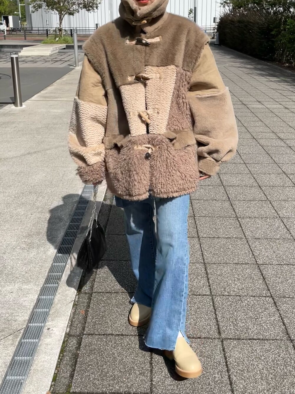 ブラウン系のジャケット/アウター、ブラック系のショルダーバッグ、ブルー系のデニムパンツを着用したレディースの秋コーディネートの9枚目の写真