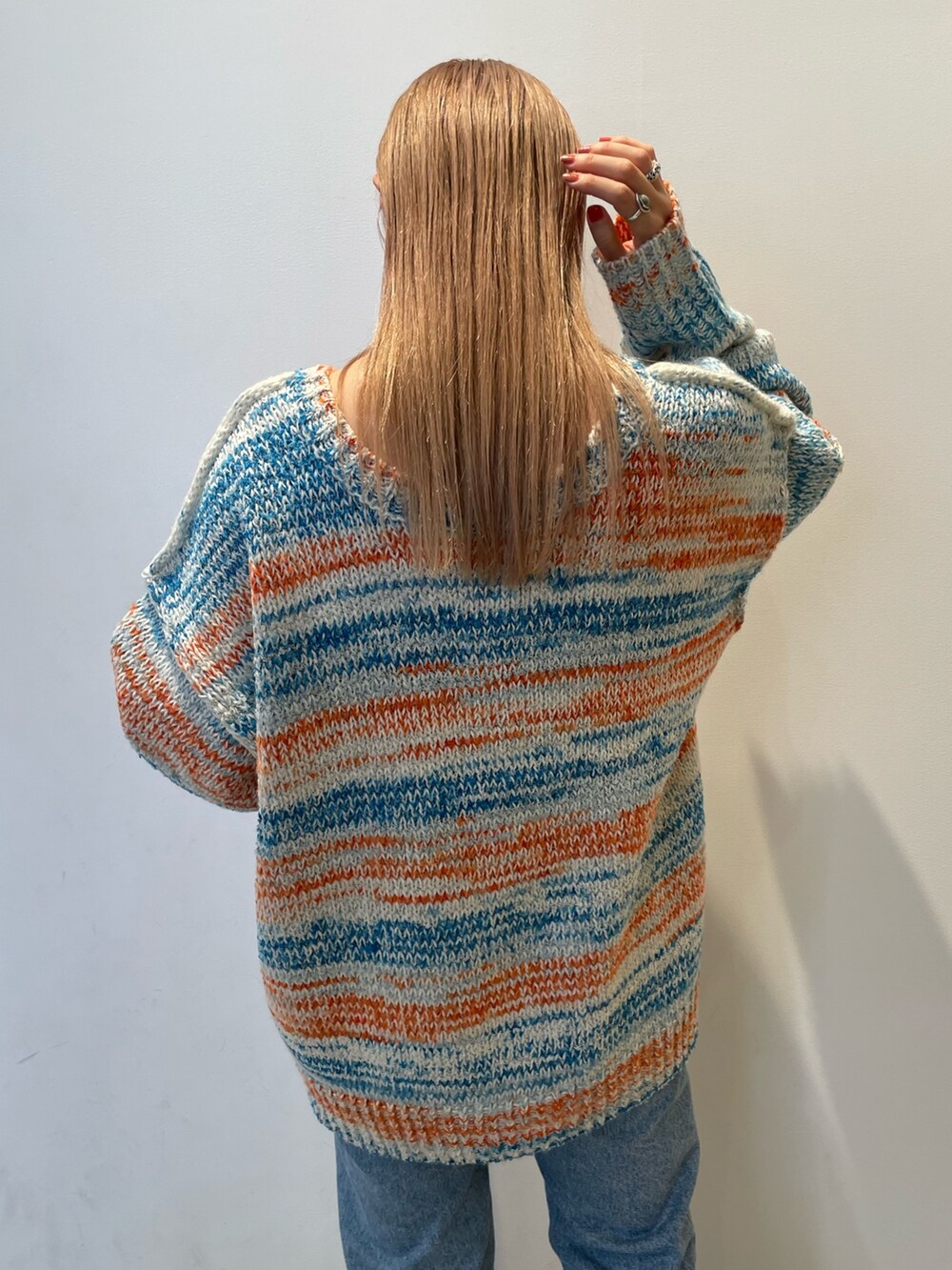 ホワイト系のカーディガン/ボレロ、ブラック系のバッグ、ブルー系のデニムパンツを着用したレディースの秋コーディネートの7枚目の写真