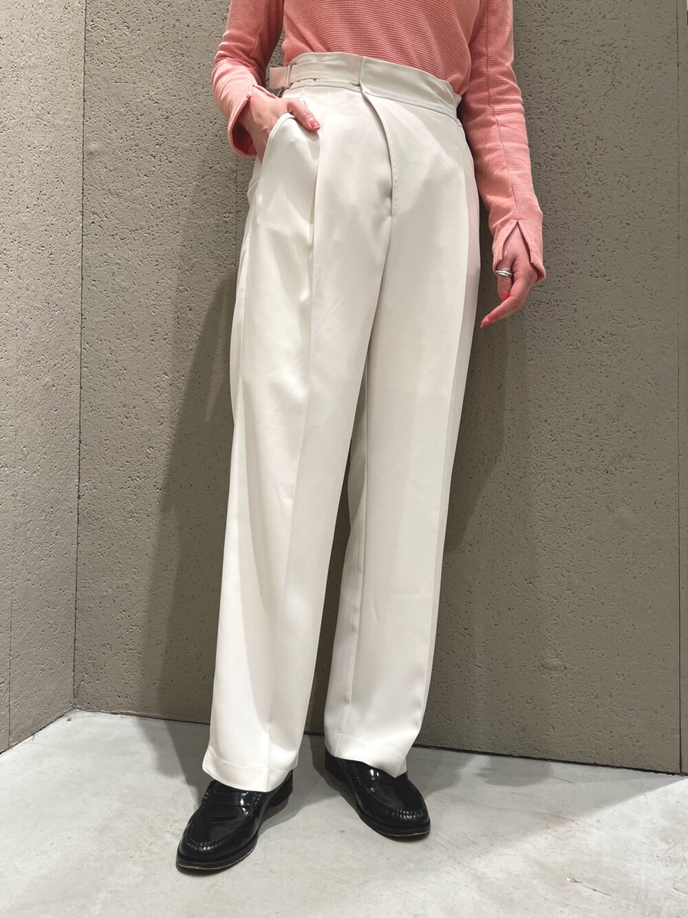 ホワイト系のベスト、オレンジ系のTシャツ/カットソー、ホワイト系のスラックスを着用したレディースの春コーディネートの5枚目の写真