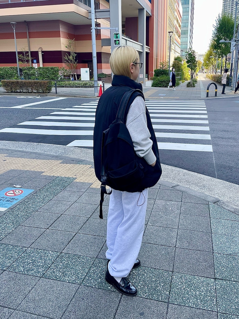 ブラック系のダウンベスト、ホワイト系のニット/セーター、グレー系のスウェットパンツを着用したレディースの冬コーディネートの3枚目の写真