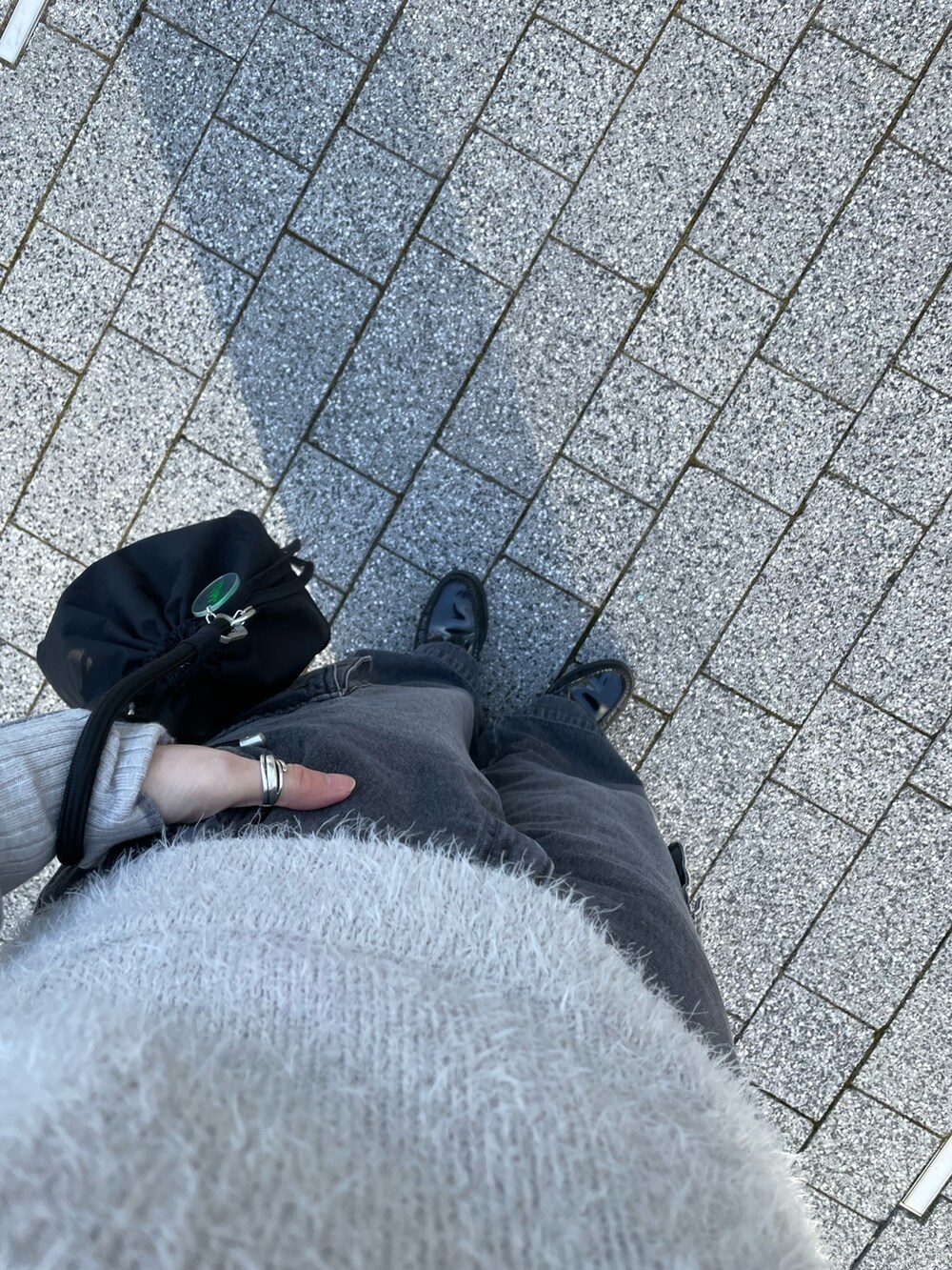 グレー系のベスト、グレー系のニット/セーター、ブラック系のバッグを着用したレディースの冬コーディネートの8枚目の写真