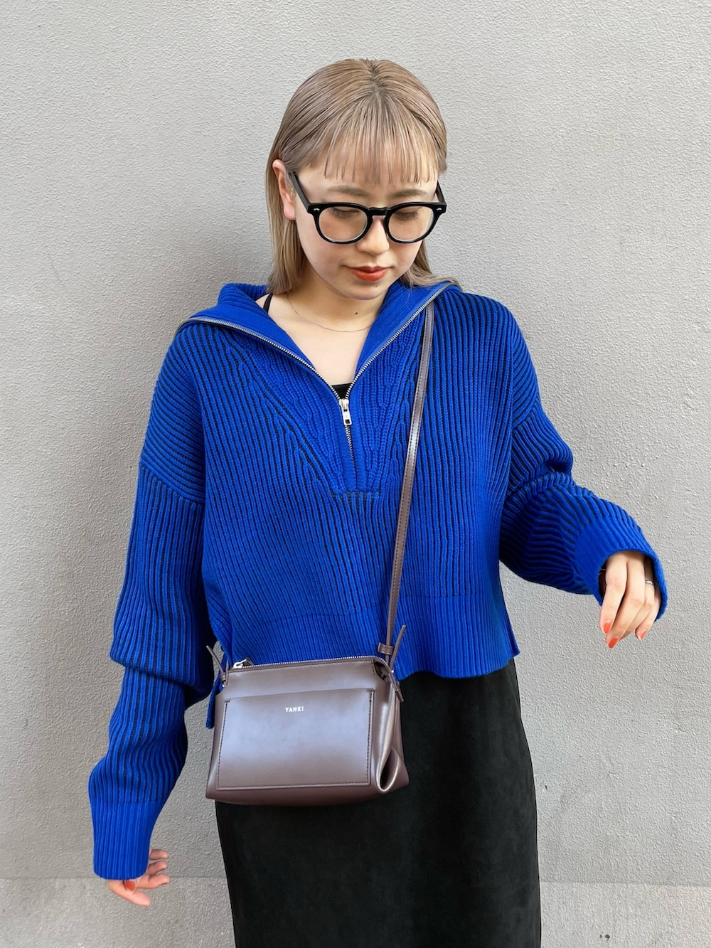 ブルー系のニット/セーター、ブラック系のワンピース、ブラック系のブーツを着用したレディースの秋コーディネートの3枚目の写真