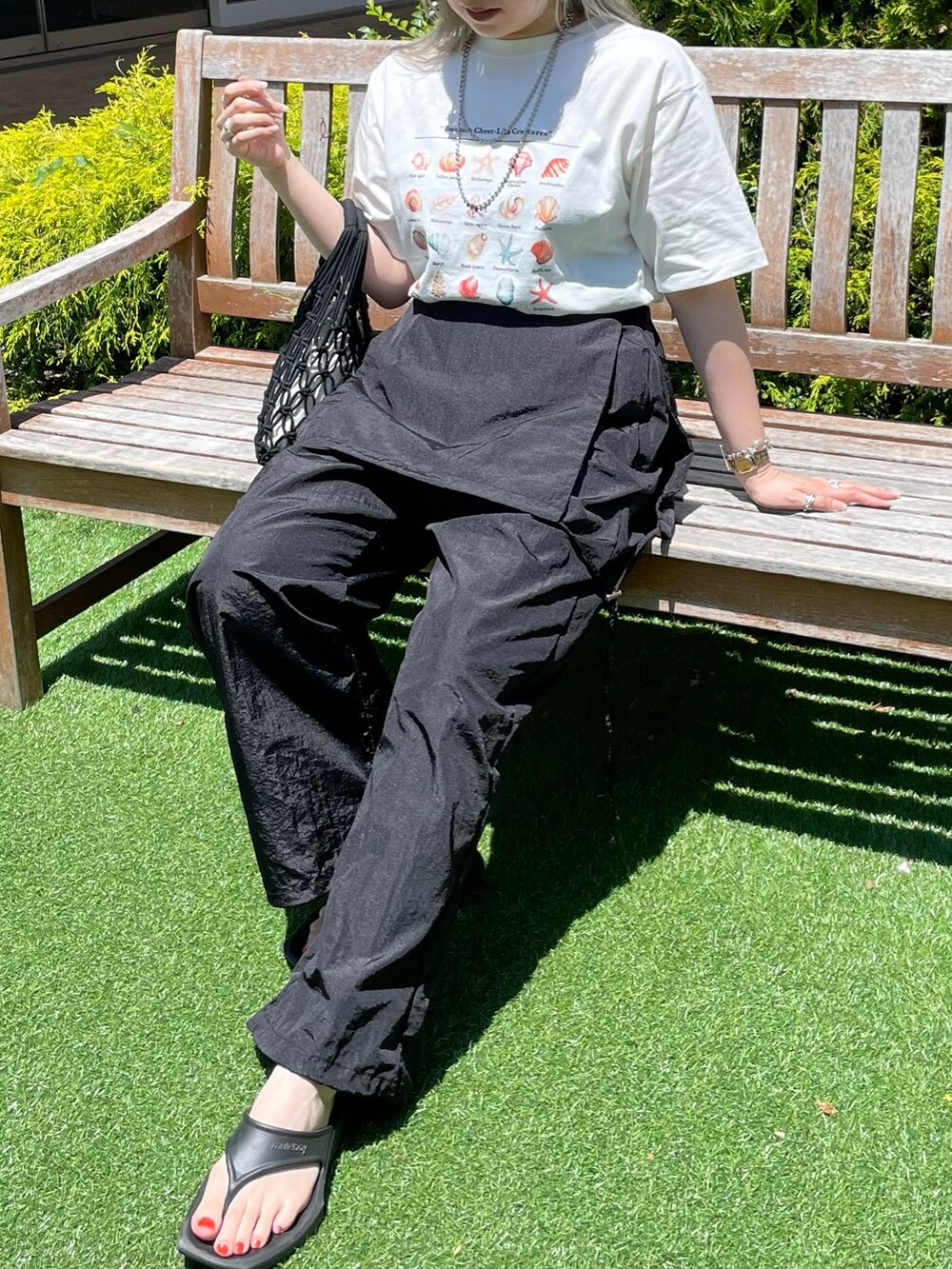 ホワイト系のTシャツ/カットソー、ブラック系のサロペット/オーバーオール、ブラック系のバッグを着用したレディースの夏コーディネートの4枚目の写真