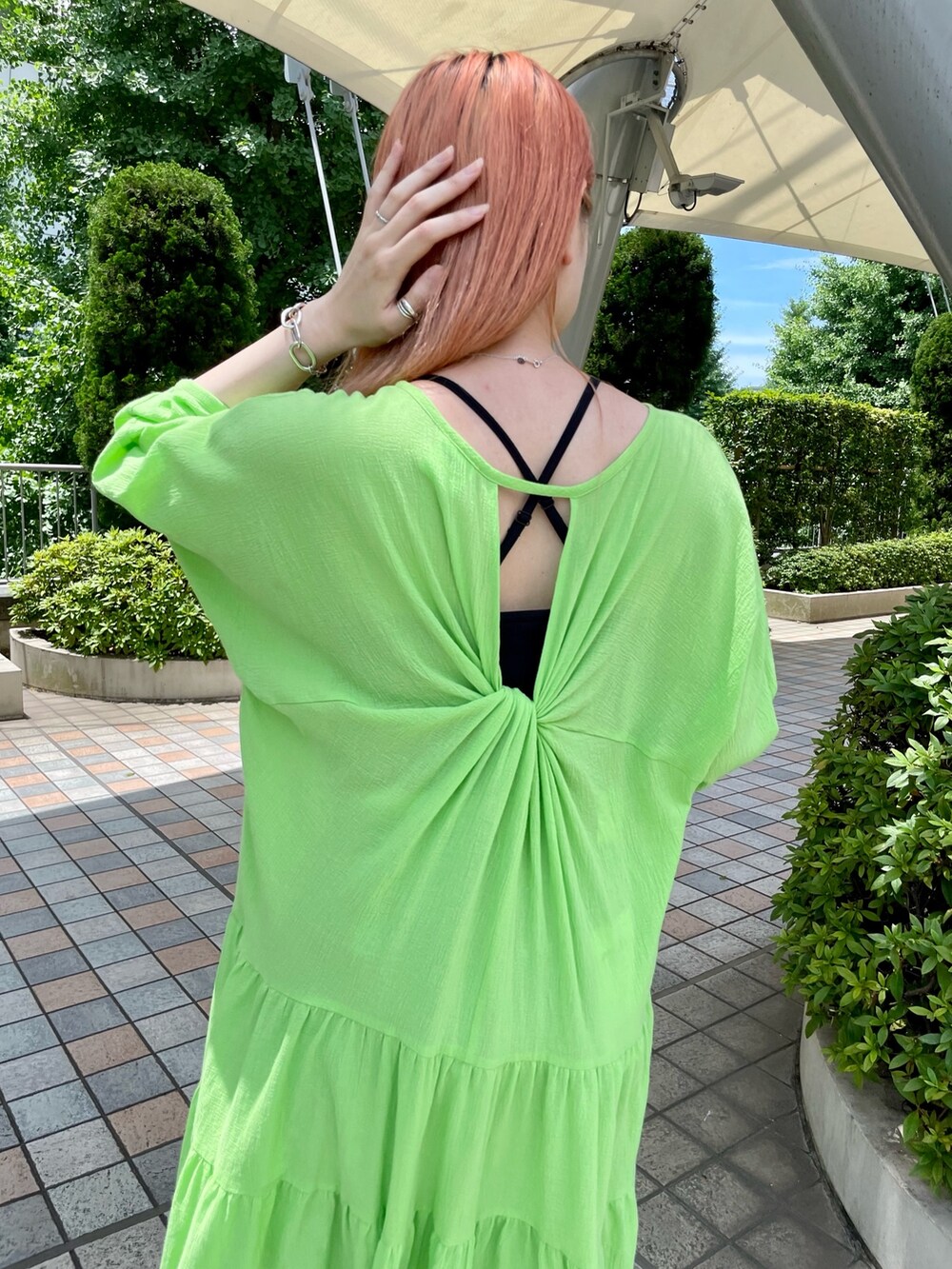 グリーン系のワンピース、ブルー系のデニムパンツ、ベージュ系のトートバッグを着用したレディースの夏コーディネートの4枚目の写真