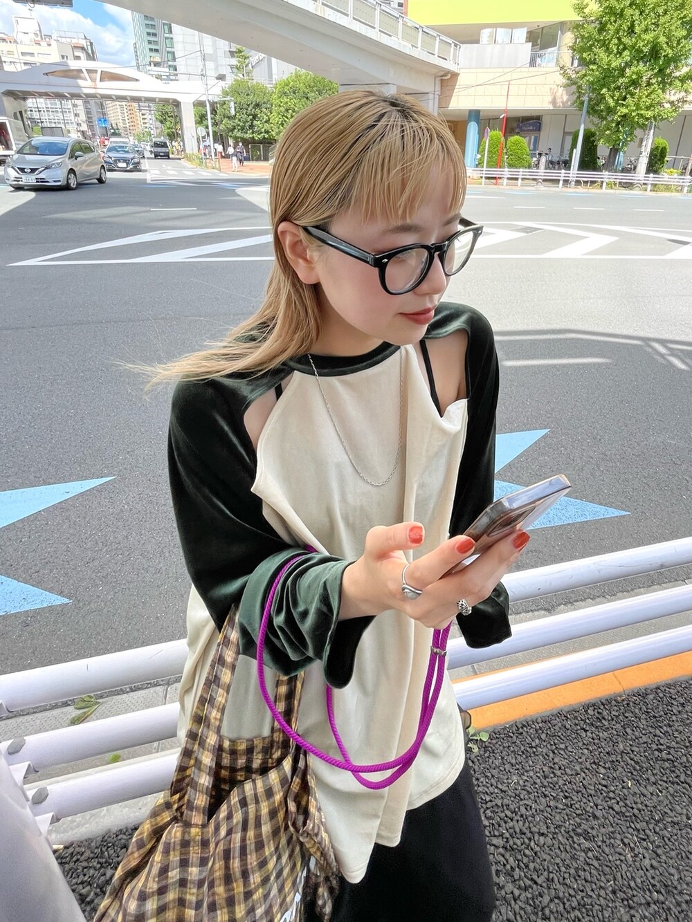 グリーン系のTシャツ/カットソー、イエロー系のトートバッグ、ブラック系のスカートを着用したレディースの秋コーディネートの4枚目の写真